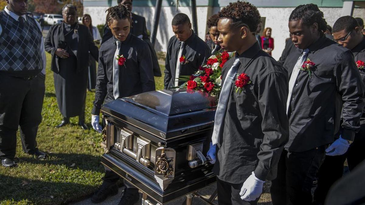 The pallbearers, family and friends of Jaulon "JJ" Clavo, escort the coffin to the hearse on Saturday, Nov. 28, 2015, in Sacramento, Calif. Hundreds of mourners gathered at Calvary Christian Center in North Sacramento to remember Clavo, the Grant High School football cornerback shot and killed in November.