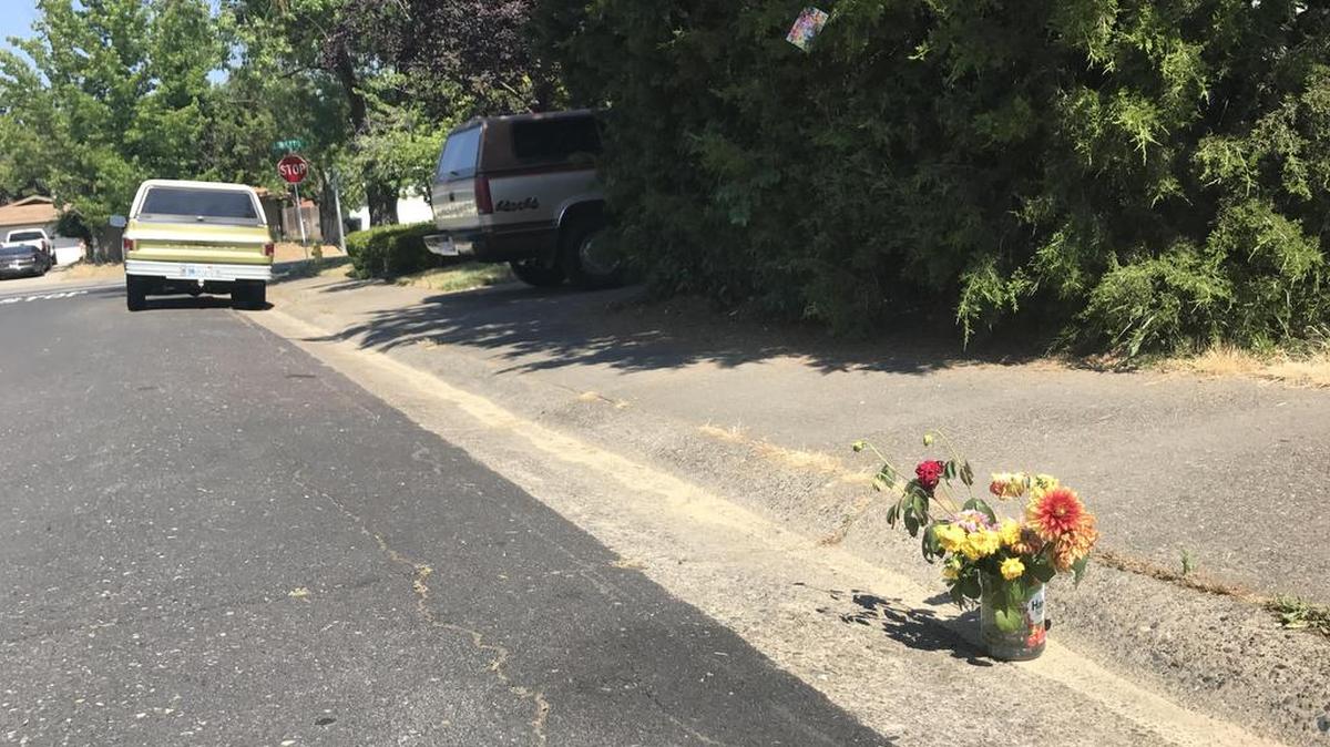 A small pot filled with wilted flowers sits Tuesday near the sidewalk on Gerry Way in Roseville, where police found a woman’s body in the trunk of a car Monday.