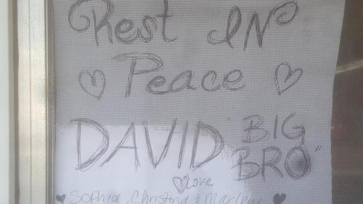 Three women put up this sign Thursday in the window of the mobile home where David Antonio Ortega II, 37, was fatally stabbed. They would not identify themselves for a reporter.