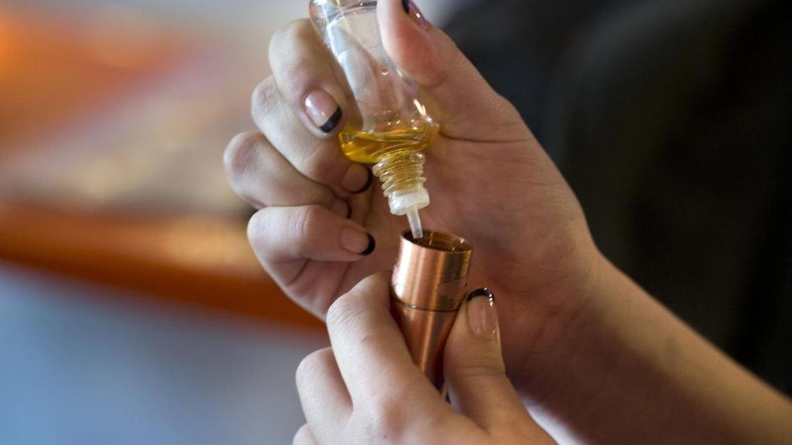 A customer adds flavored propylene glycol and vegetable glycerin to her e-cigarette at The Vapor Spot on J Street in midtown on Wednesday, Jan. 27, 2015 in Sacramento.