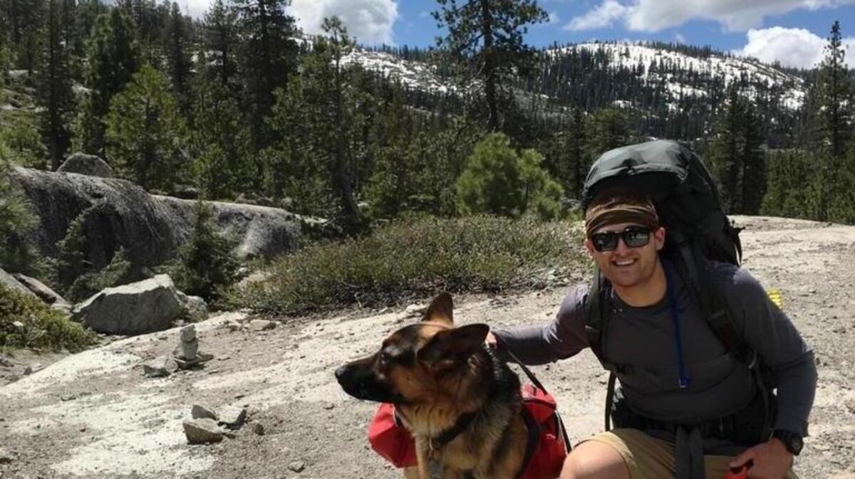 Cody Michael poses with his dog in a photo sent to his family Monday