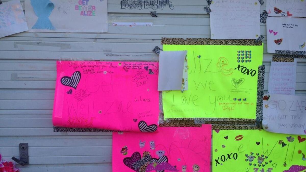 Signs of support from friends and family are posted on the West Sacramento garage of a home where a 13-year-old girl was critically injured in a drive-by shooting.