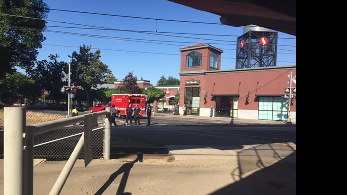 
Fire, police and Regional Transit workers stand at the site where a light-rail train brushed a bicyclist about 8 a.m. Wednesday.
