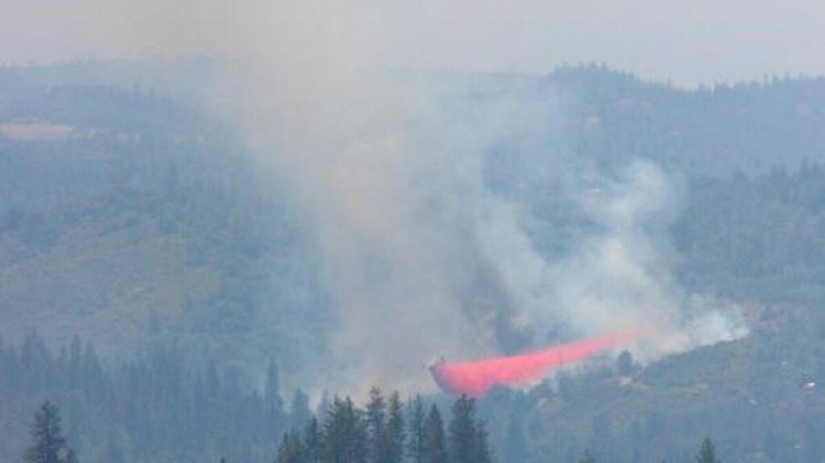 An air tanker drops fire retardant to slow the advance of the Aukum fire burning about 5 miles south of Placerville in El Dorado County on Friday, June 3, 2016.