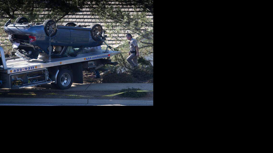 
California Highway Patrol Officer Phillip McCain walks through the wreckage left by a car that was allegedly stolen early Wednesday morning by a suspect in a shooting at a restaurant/bar in El Dorado Hills
