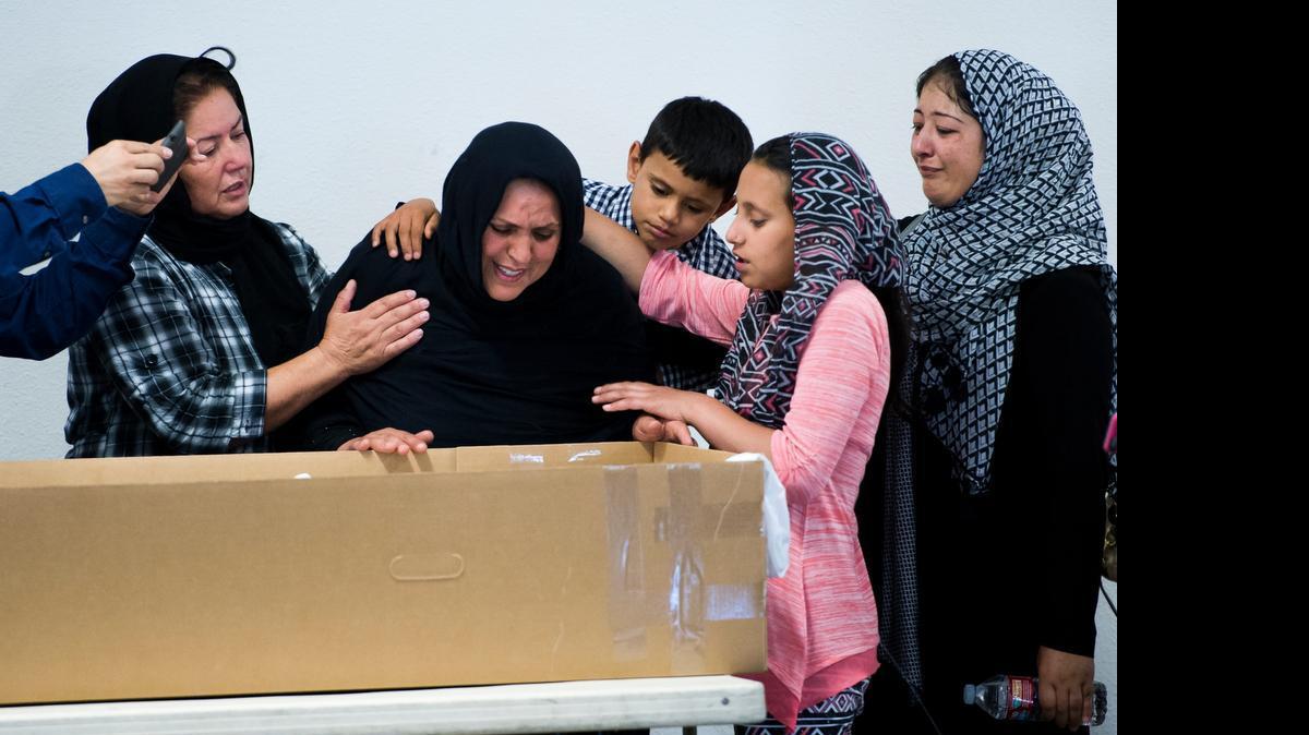 
Malalai Rafi, center, grieves for her husband Mustafa Rafi, who was struck by a car and killed while riding his bike on Sunday in Sacramento. Two of their four children, Imran, 6, and daughter Mariam, 13, support their mother along with community members at the Muslim Mosque Association on Tuesday in Sacramento. Rafi’s son, Omar, 8, was injured and remains in intensive care. 
