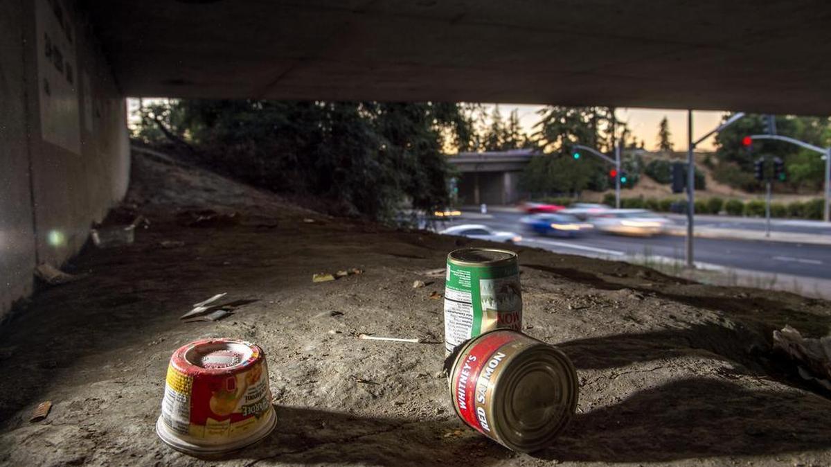 Empty food cans and other trash are what remains at a homeless encampment where last year a homeless woman was murdered at Broadway and Alhambra in Sacramento.
