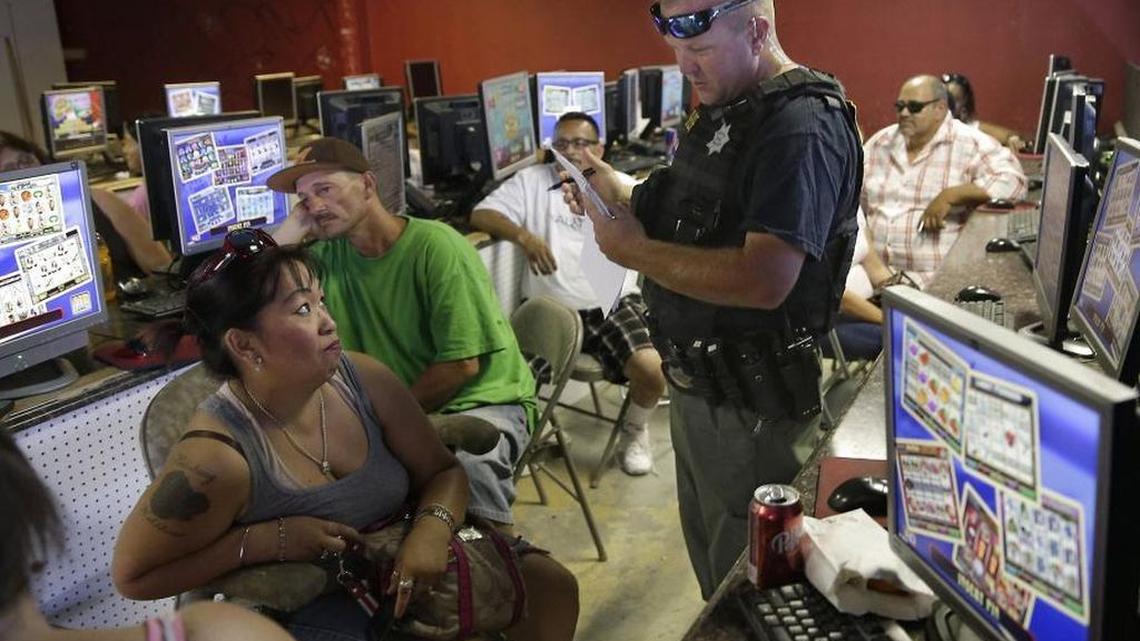 
Sweepstakes games are visible on screens in June 2014 as a Sacramento County deputy conducts a code enforcement raid on the Silk and Stars business in south Sacramento. 
