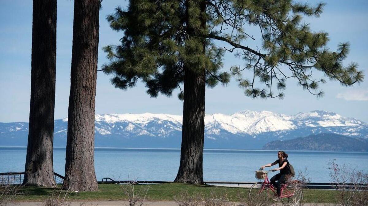 FILE -- A bicycle rider pedals along a bike trail which parallels Highway 50 on Tuesday, May 2, 2017 in South Lake Tahoe, Calif.