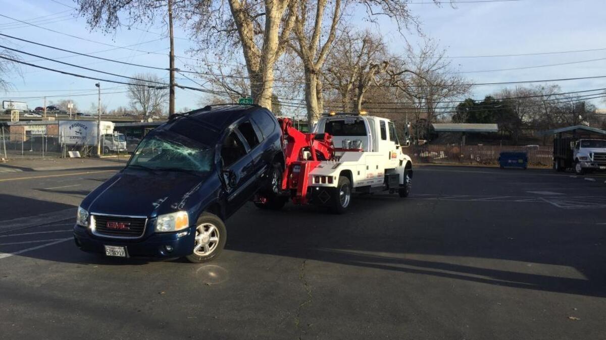 A GMC Envoy is towed after a two-vehicle crash Thursday morning at Fifth Street and Broadway in Sacramento.