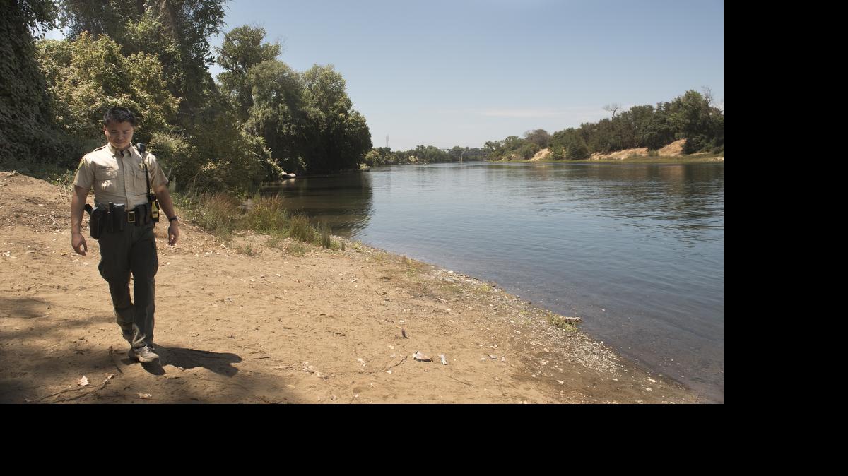 
Sacramento County park ranger Eric Chieng points to the site where a body was found in the American River near Sutter's Landing in midtown Sacramento today.
