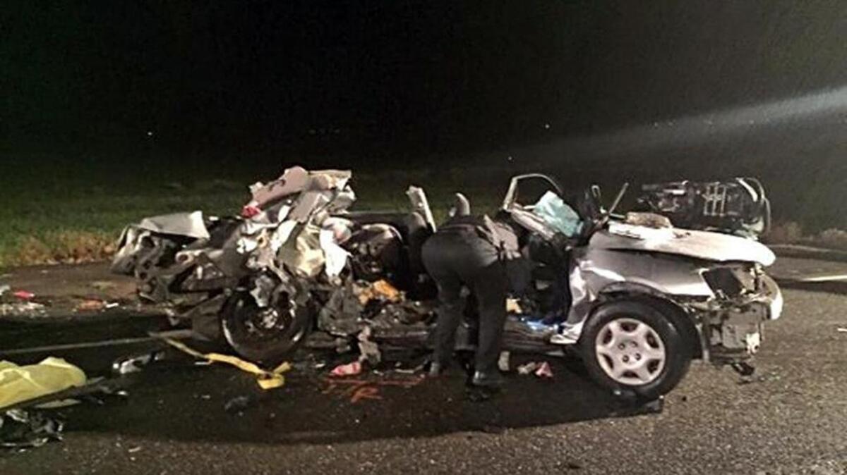 In this April 9, 2016 photo provided by KCRA-TV, an investigator views the wreckage of a Honda Civic that slammed head-on into an oncoming Chevrolet Silverado pickup truck, killing all five occupants, on a two-lane highway in Rio Vista, Calif., about 40 miles southwest of Sacramento.