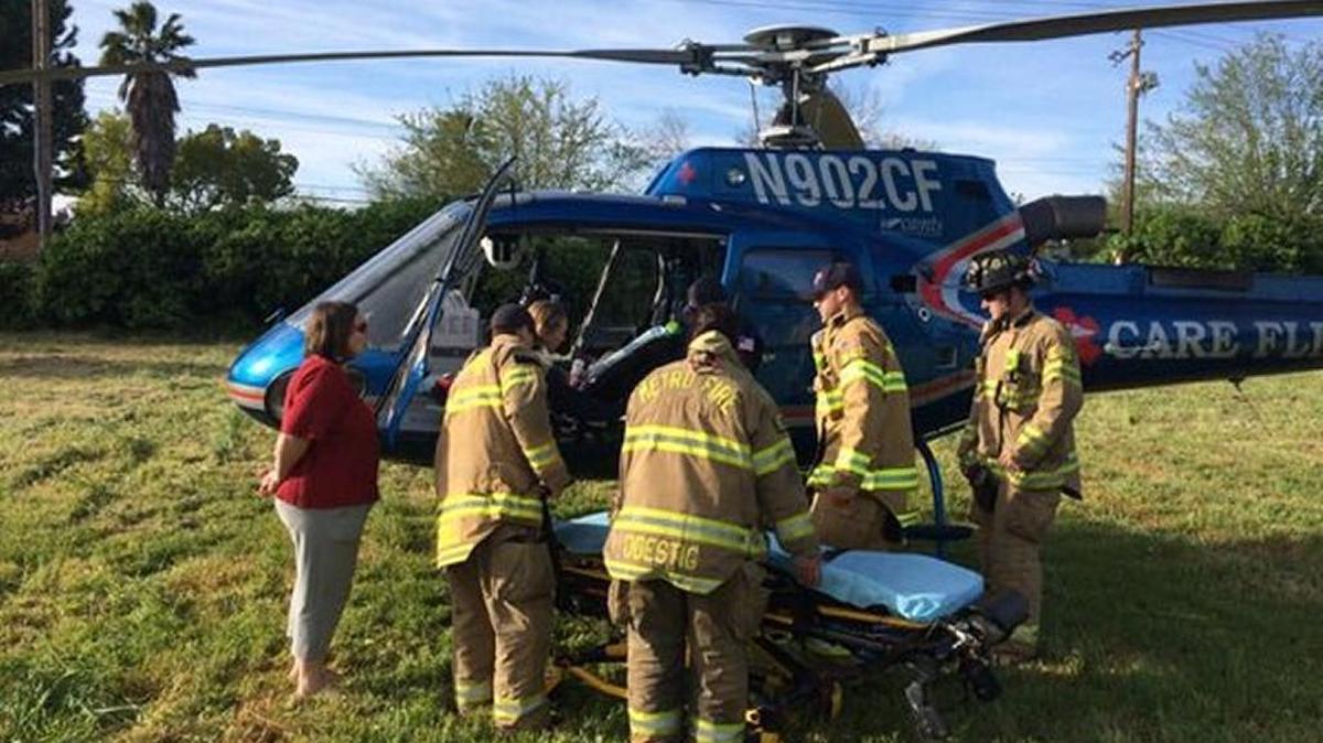 A child is transferred from a helicopter to a ground ambulance following an emergency landing in a field in Rancho Cordova.