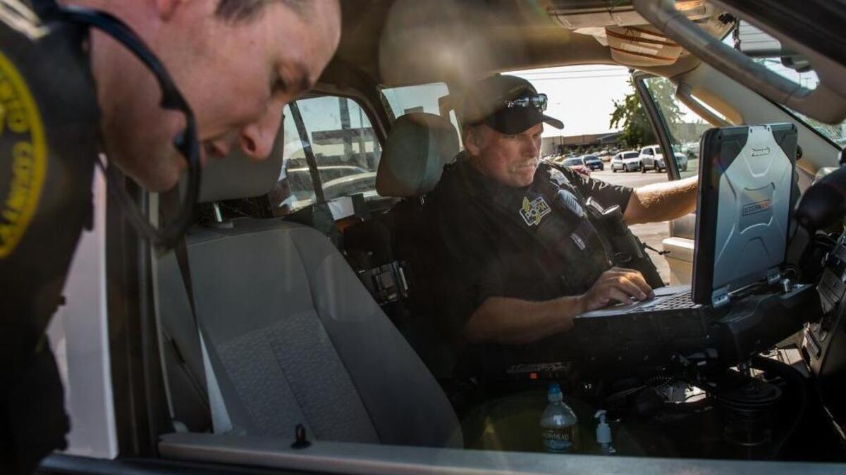 Sacramento County Sheriff’s Department Deputy Tom Mantei checks the background of a woman soliciting prostitution near Watt Avenue on Aug. 7, 2015.