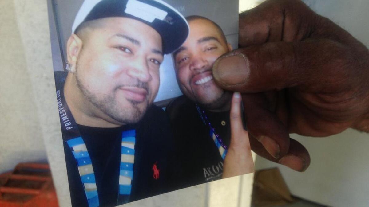 
Clarence Johnson, father of the victim, held up a photo of his son Kevin Johnson and his second cousin, on the front porch of the Franklin Boulevard home Saturday evening.
