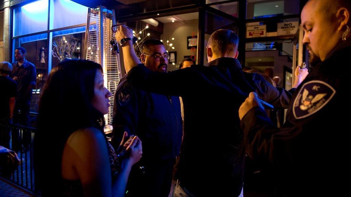 Security personnel Ricardo Cueto, center, and Giovanni Escobar, right, check IDs and use a detection wand at the entry to the Parlare Euro Lounge on 10th Street in downtown Sacramento on March 28, 2013.