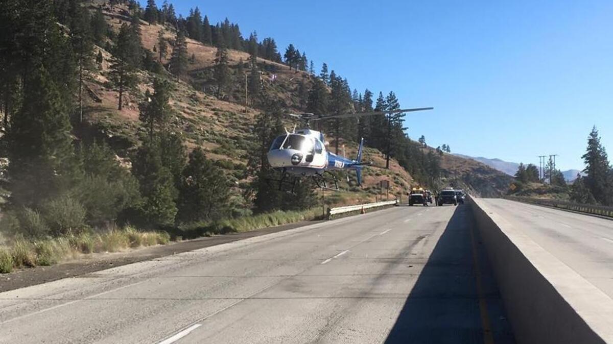 A helicopter lands at the crash site at the Nevada State Line.