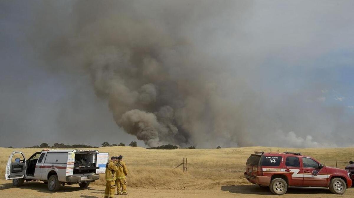 CalFire and Sacramento Metro Fire personnel work a grass fire along Michigan Bar Road at the east end of Sacramento county near El Dorado county south of US 50.