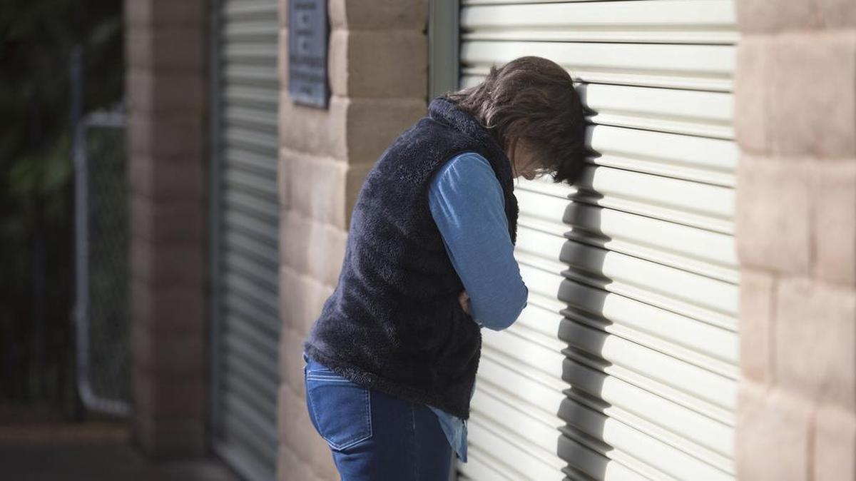 Sondra Winberry leans her head on a roll up door at the Georgetown fire station where officials are coordinating the search for Winberry's sister Susan Holloter and her husband Rory on Friday, November 28, 2016 in Georgetown. The couple got lost while driving off road somewhere near Ice House and Wentworth Springs on Saturday.