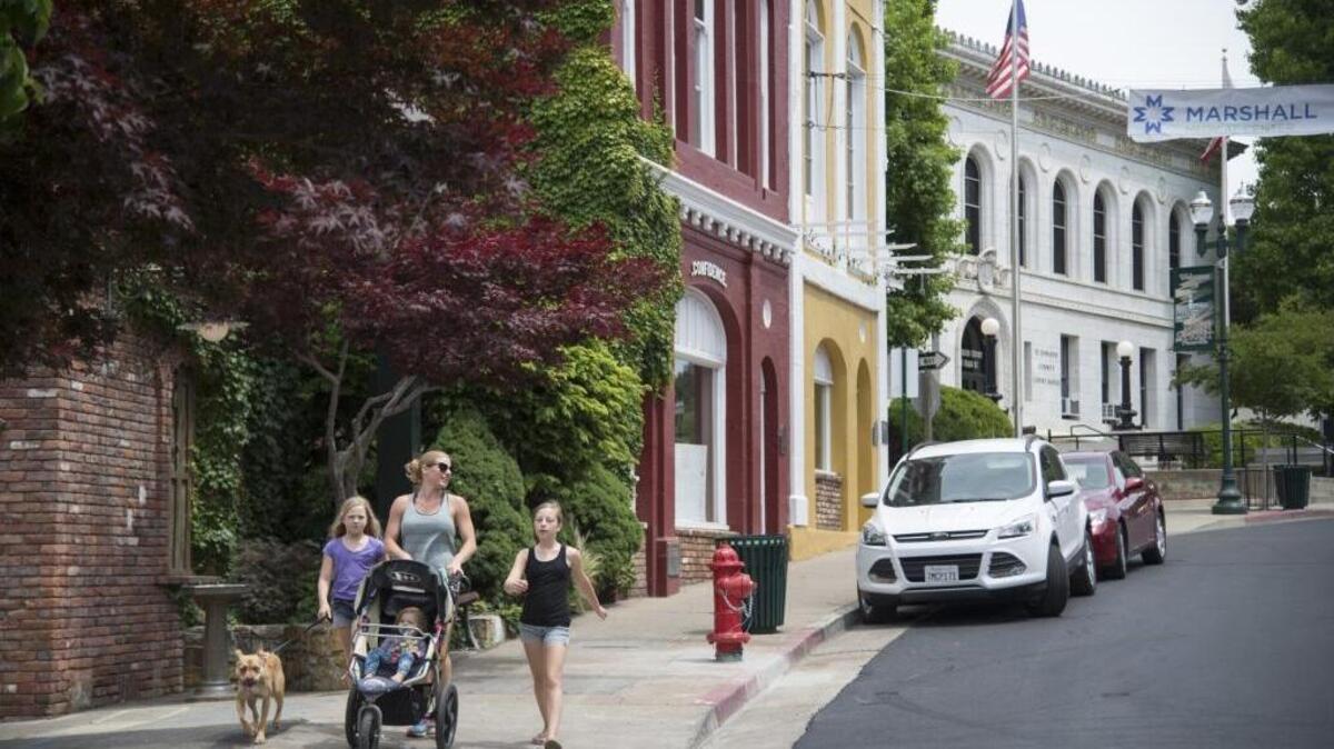 Families walk down Main Street in downtown Placerville, Thursday, May 19, 2016. Placerville’s downtown courthouse has anchored Main Street for over 100 years, but current plans call for building a new courthouse on the west end of town behind the El Dorado County jail. Some are enthused about the prospect of a modern courthouse; the old one is cramped and outdated. Others have filed a lawsuit, saying the move will harm Placerville’s historic downtown and lead to blight.