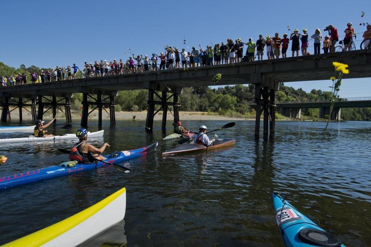 Eppie Johnson’s family and friends throw a wreath and flowers into the American River during a memorial to honor Eppie Johnson, Sacramento restaurateur and originator of the annual Eppie’s Great Race in 2014.