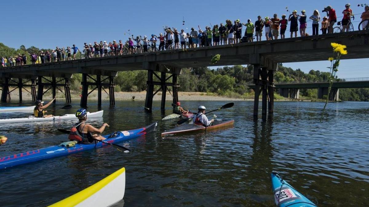 Eppie Johnson’s family and friends throw a wreath and flowers into the American River during a memorial to honor Eppie Johnson, Sacramento restaurateur and originator of the annual Eppie’s Great Race in 2014.