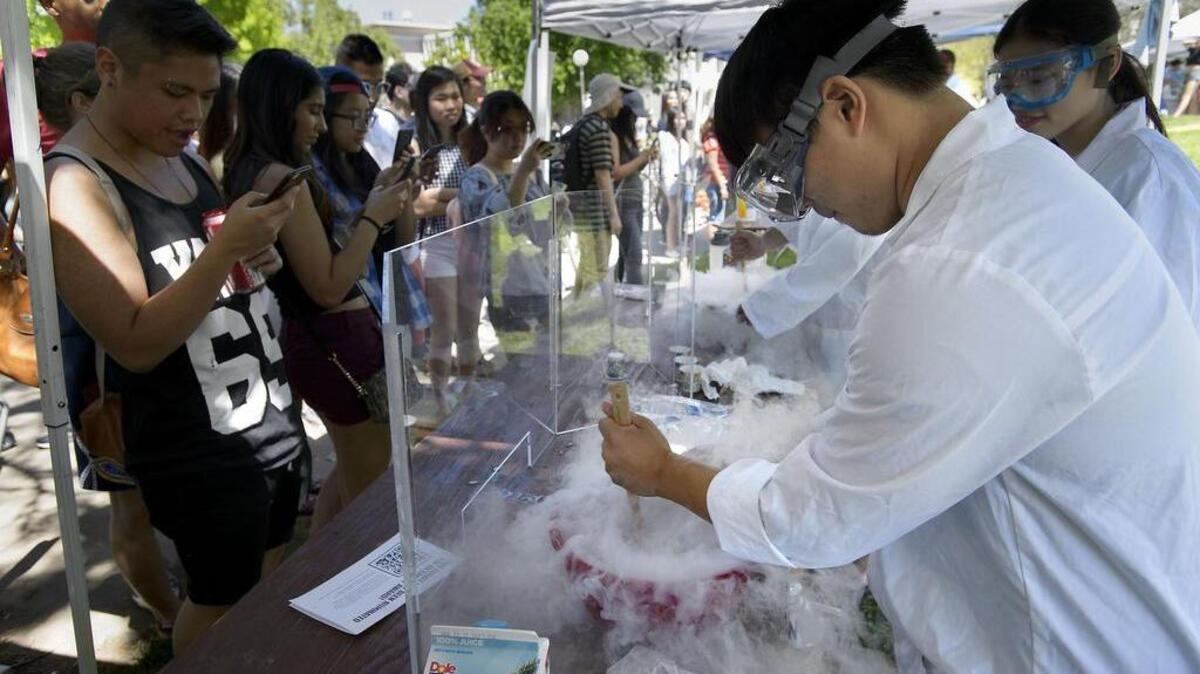 Chemical engineering student Matthew Wang, right, mixes liquid nitrogen and fruit juice to make an instant sorbet as hundreds line up for a taste during the 104th annual Picnic Day event at UC Davis on Saturday.