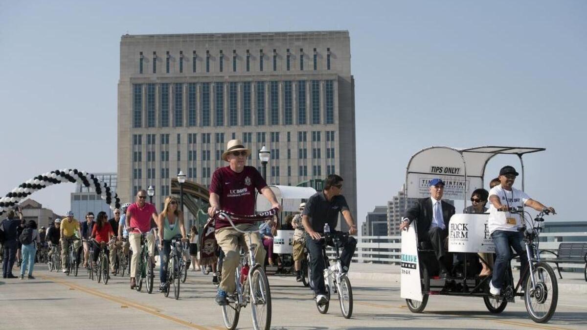 Cyclists join Downtown Railyards Venture LLC principal Larry Kelley and Congresswoman Doris Matsui, right, for a ride on the Fifth Street overcrossing during the grand opening celebration of the roads in the downtown Sacramento railyard on Friday, August 19, 2016 in Sacramento, Calif. The City of Sacramento would like to extend Fifth Street north of the railyard into the River District.