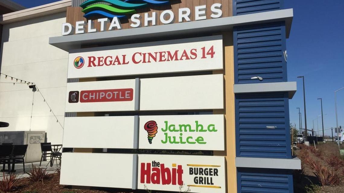 A sign near the front of the Delta Shores complex lists Regal Cinemas 14 among the center’s businesses.