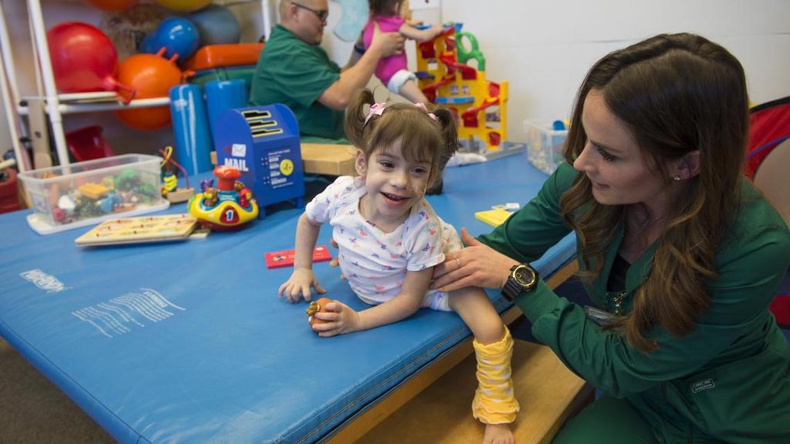 Formerly conjoined twins, Erika, (front) and Eva Sandoval, 2, receive rehabilitation therapy at the UC Davis Medical Center, Wednesday, March 29, 2017, from therapists, Rachel Hammond, right, and Alexis Bonzon. The twins will be released from the hospital Wednesday, and go home to Antelope for the first time since their separation surgery in December.