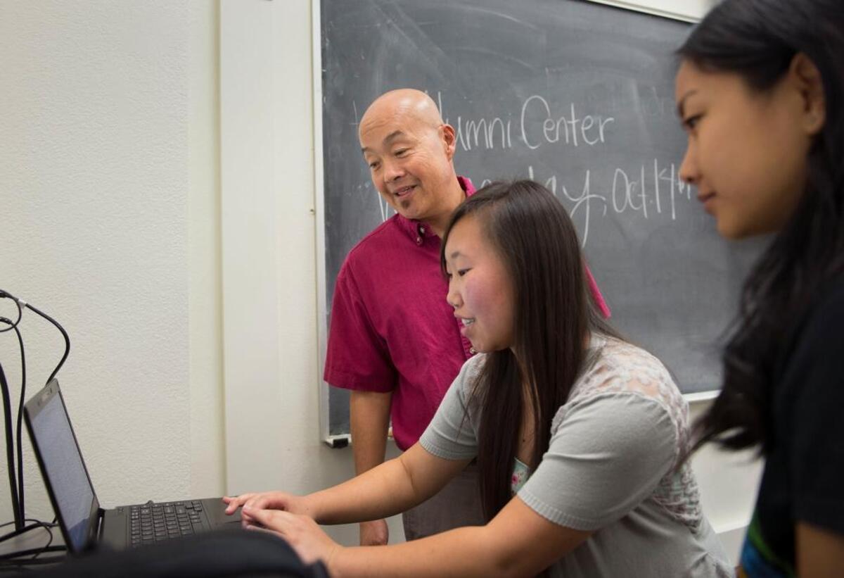 Full Circle Project director Tim Fong, left, confers with student mentor Pakou Her before the start of an ethnic studies class required for first-year FCP participants at Sacramento State on Monday.