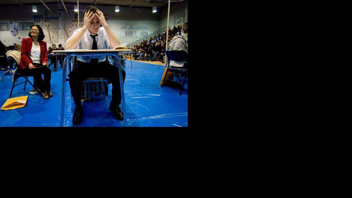 
With proctor Lora Nishimura looking on, Nathan McCurley puzzles at the answer to a question during the Sacramento County Academic Decathlon Super Quiz at Valley High School on Feb. 2, 2008. 
