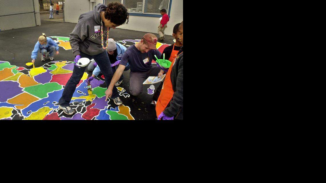 
Volunteer instructor Ariana Ebrahimian, middle, leads a team of volunteers in painting the world map on the blacktop at the St. Hope Charter School PS7 in Oak Park Nov. 6, 2003. During the daylong project, parent volunteers and Home Depot employees installed playground equipment, landscaped the school grounds, painted murals, built benches and picnic tables.
