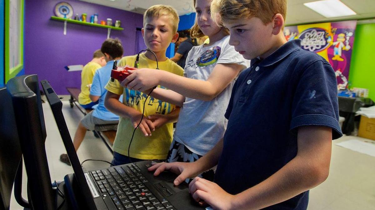 Mad Science student Anthony Lunardi, 8, left, Jordan Bradbury, 9, and Liam Walton, 10, use a laptop computer to program a small robotic device during an Advanced Robotics Summer Camp at the Mad Science Laboratory . A goal of the camp is to give students a hands-on experience and take-home projects for an appreciation of science.