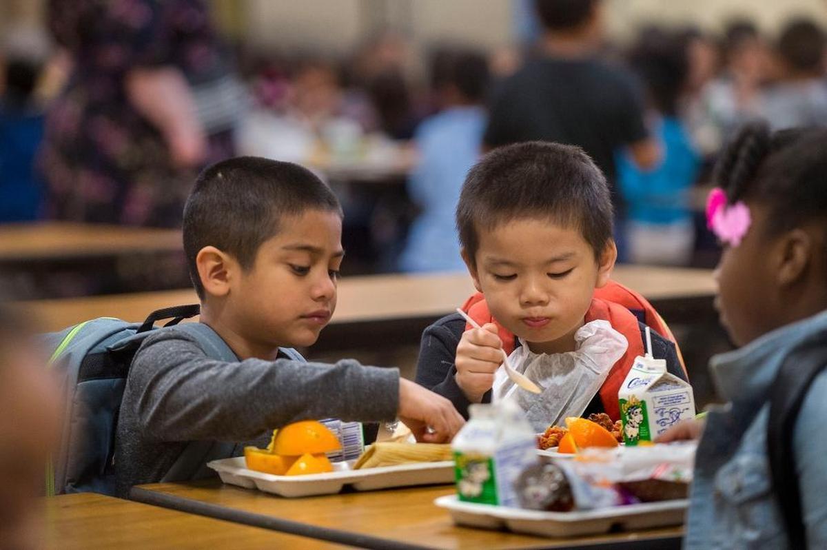 Kindergarten students Alan Corona Olguin, left, and Aidan Chang enjoy a school lunch at Ethel Baker Elementary School in Sacramento on Thursday, April 14, 2016.