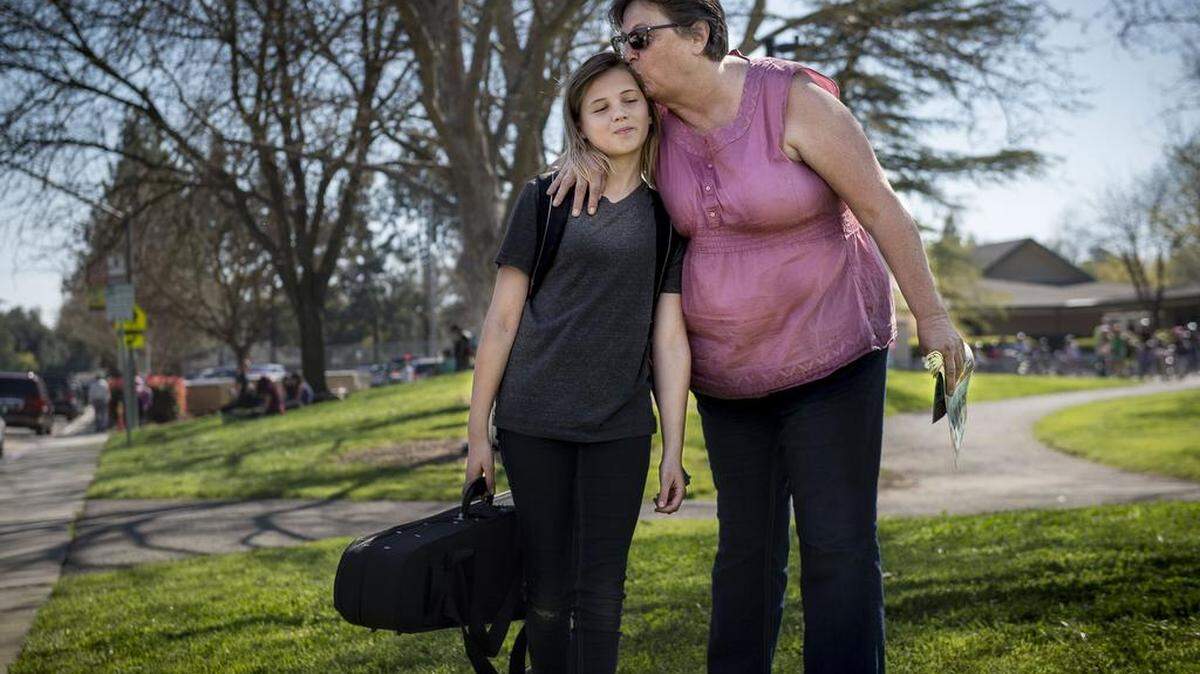 Helen Pomerleau of Woodland kisses her granddaughter Makayla, 11, as she picks her up at Willett Elementary in Davis last year. The family is one of hundreds who drive their children to Davis Joint Unified School District every day.