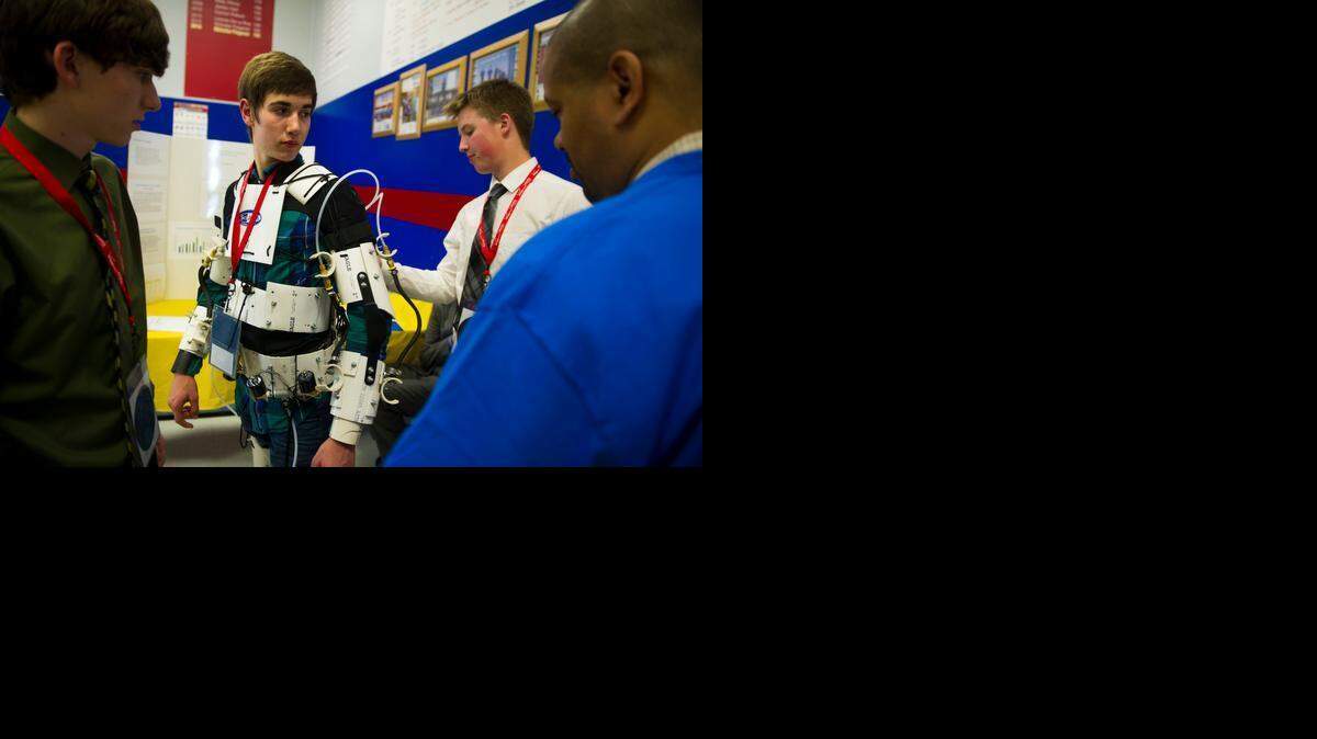 
Wyatt Lacroix, left, Henry Jorrick, second from left, and Logan Mariti present Project Titan, the exoskeleton they made for the STEM Fair, to STEM Fair judge Chaise Vidal at the STEM Fair at Folsom High School on Saturday. The three students attend the Academy of Personalized Learning in Redding. 
