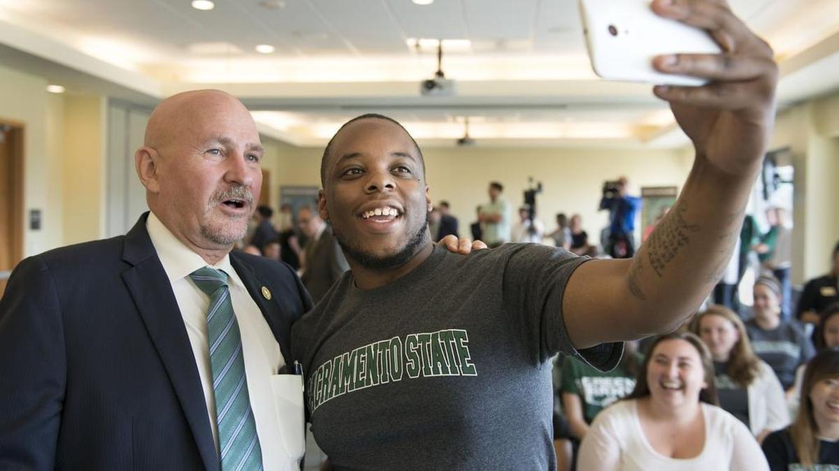 
Sacramento State President Robert Nelsen stands next to graduate student Damariye Smith, 24, who takes a selfie before Nelsen is formally introduced during a news conference at Sacramento State last month. 
