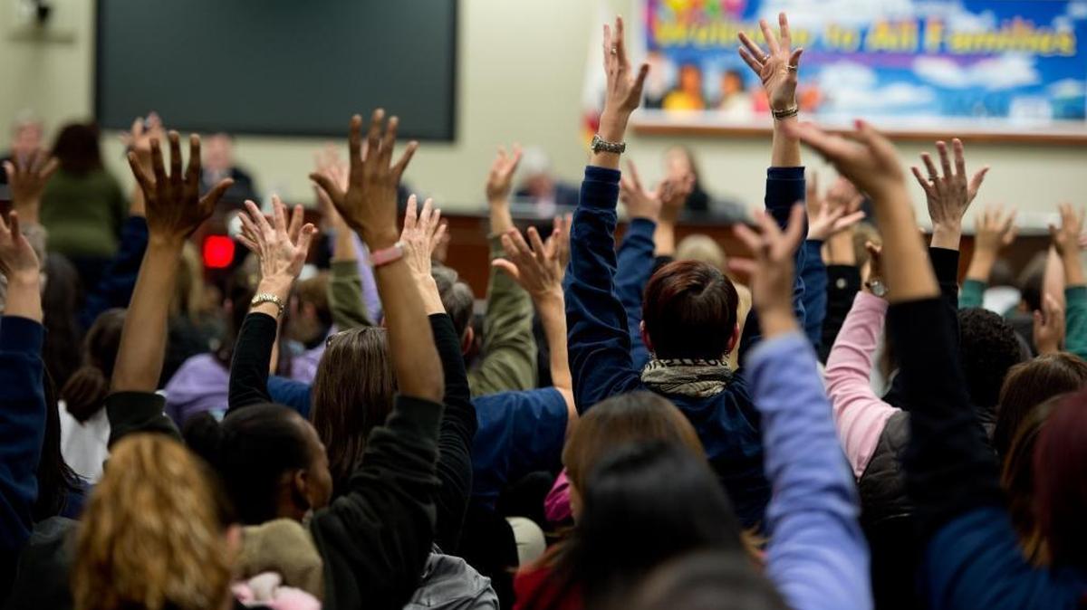 Parents and supporters raise their hands in silent applause after listening to Bret Harte Elementary School teacher Rachelle Gray at a Sacramento City Unified School District board meeting on Thursday, Jan. 17, 2013.