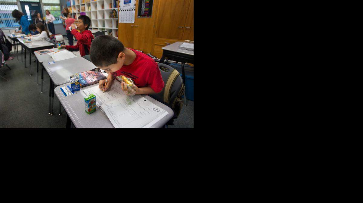 
Hovhannes Muradyan 10, eats breakfast while doing his schoolwork at his desk at White Rock Elementary School in Rancho Cordova on Friday. Low-income students at White Rock Elementary School eat a free breakfast in their classrooms. 
