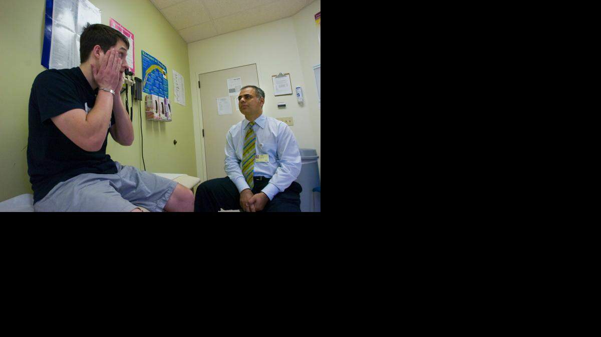 
Marvin Green, then 19, meets with Dr. Amer Khan, a pediatric neurologist, about his migraines and sleep problems at the Sutter Cancer Center, June 22, 2008. 
