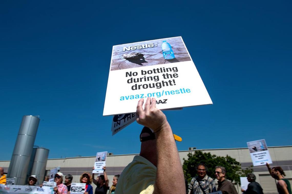 A protester holds up a sign in Sacramento during a 2015 rally outside Nestle Waters to try to stop bottling California water during the drought.