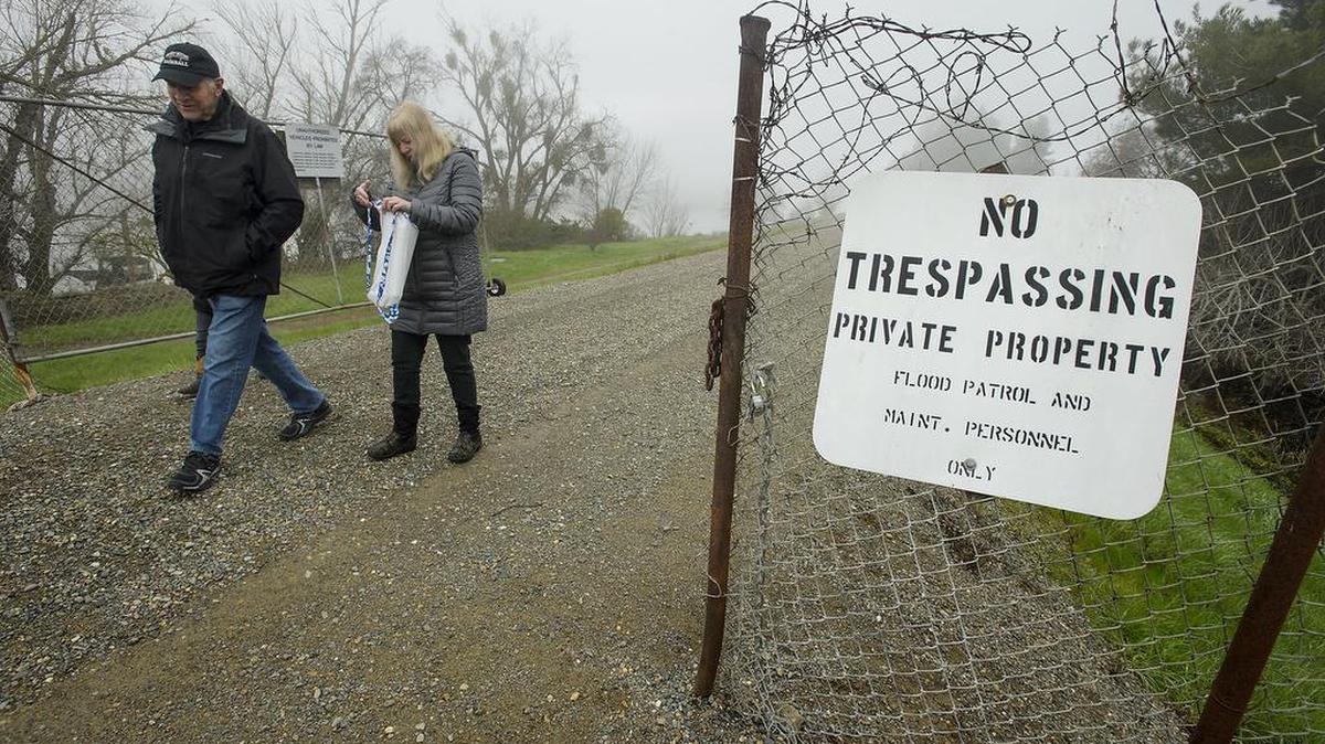 Neighbors Don Murphy, left, and Billyann Groza inspect the vandalized gate on the levee behind their homes in Sacramento on Friday, January 26, 2018. Murphy's home is along the Sacramento River, and he owns the levee there. The city wants to take control of the levee behind his home and build a paved bike trail.