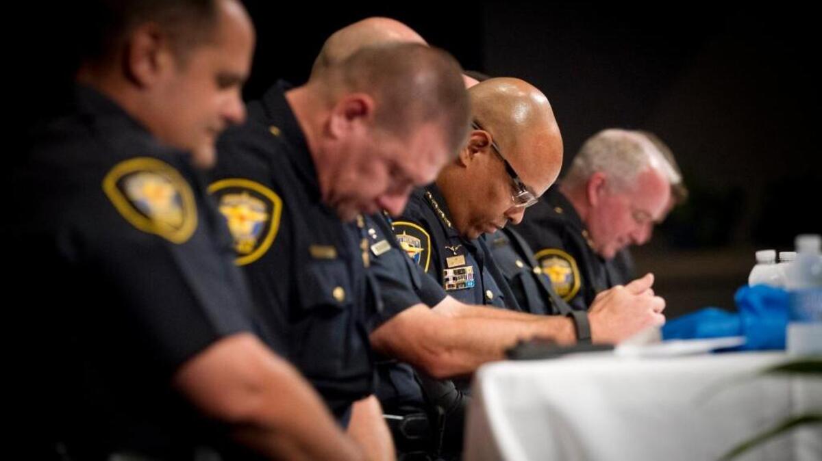The Fort Worth Police Department held a Police Forum "to inform and be informed about issues impacting our community" on Tuesday, July 26, 2016. Police Chief Joel Fitzgerald, center, and members of his command team, bow their head in prayer as the forum gets underway in the Great Commission Baptist Church. Two police officers from the department generously bought a 95-year-old a new air conditioning unit last week.