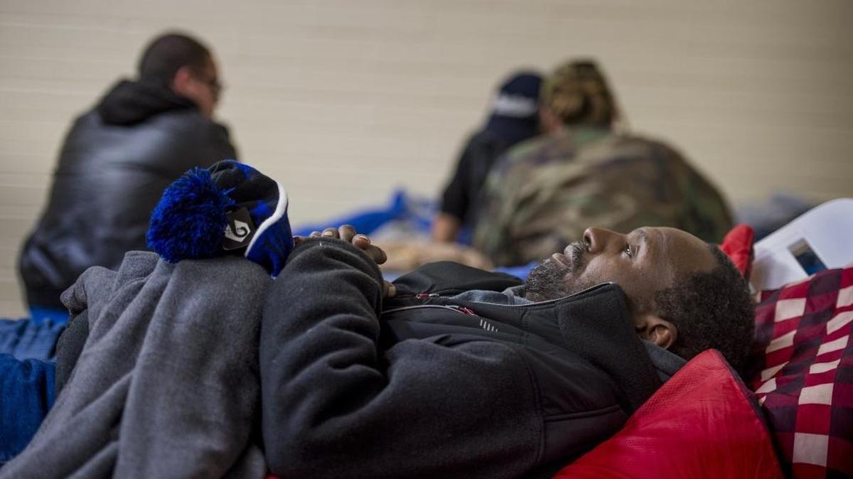 Stafford Nichols beds down for the night on a pool recliner inside a homeless “warming center” at the pool-house at Southside Park on Tuesday night, December 27, 2016. The warming center is scheduled to close the first week on January 2017.