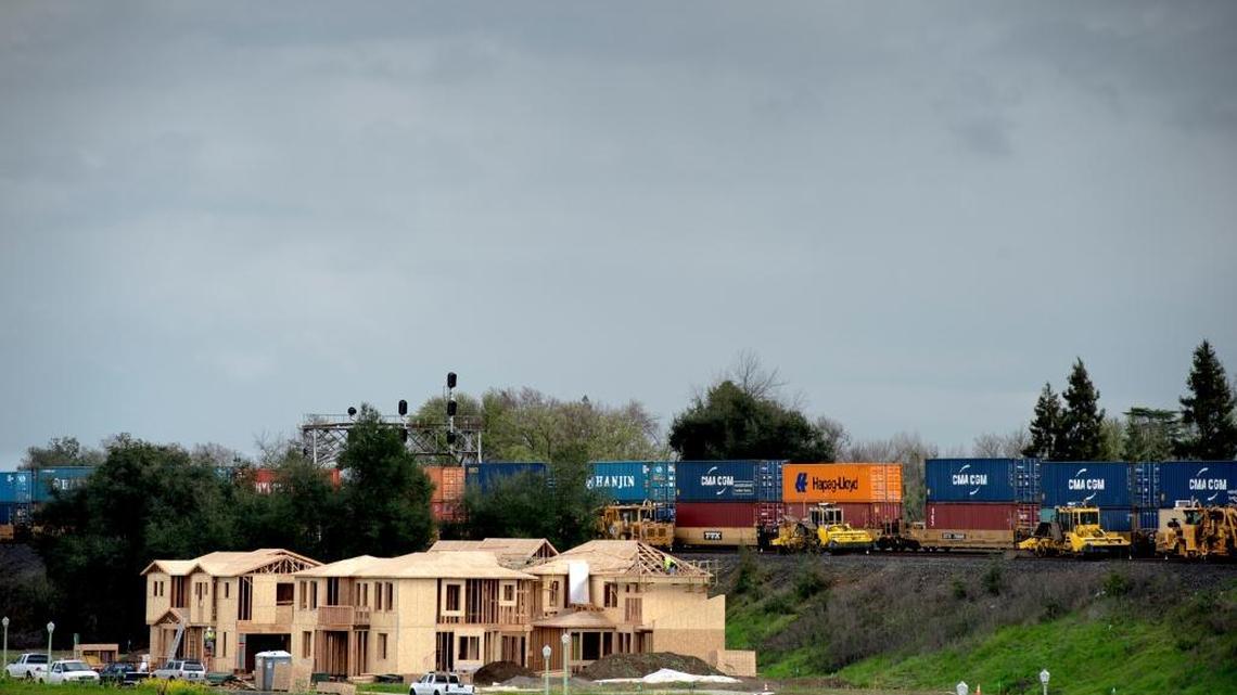 A freight train passes model homes under construction at the new McKinley Village development in Sacramento, Calif., on Thursday, Feb. 18, 2016.