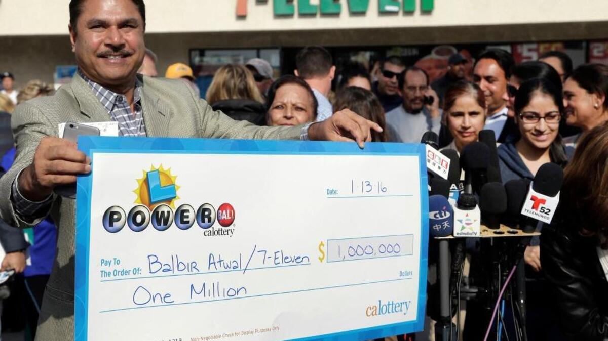 Balbir Atwal owner of the 7-Eleven store that sold one of the winning Powerball tickets, holds the check he received for $1 million dollars at his store in Chino Hills, Calif. on Thursday, Jan. 14, 2016.