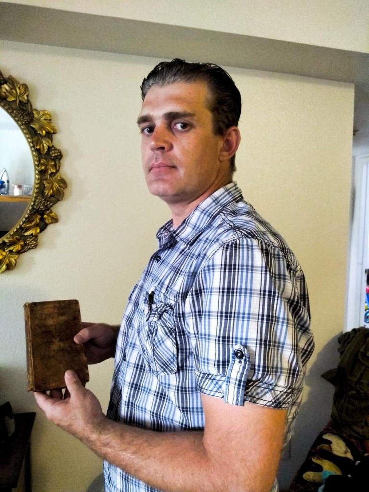 Max Brown poses with Lectures of Rhetoric and Belles Lettres, a book he found alongside volumes of Thomas Jefferson’s library in a Sierra dumpster.