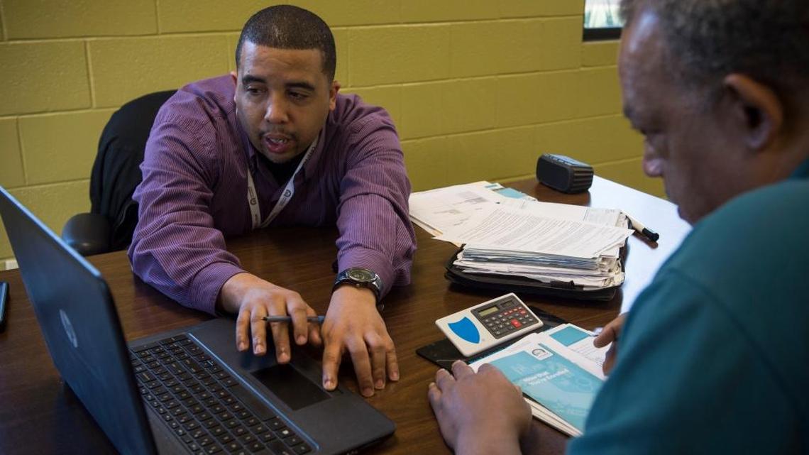 Jamel Johnson, left, goes over health insurance plans Wednesday with Mark Burch at 1Solution. Sunday is the deadline for most uninsured people to enrollment in Covered California health care policies for 2016. Those who forget or ignore the deadline will face a stiffer federal tax penalty next year.