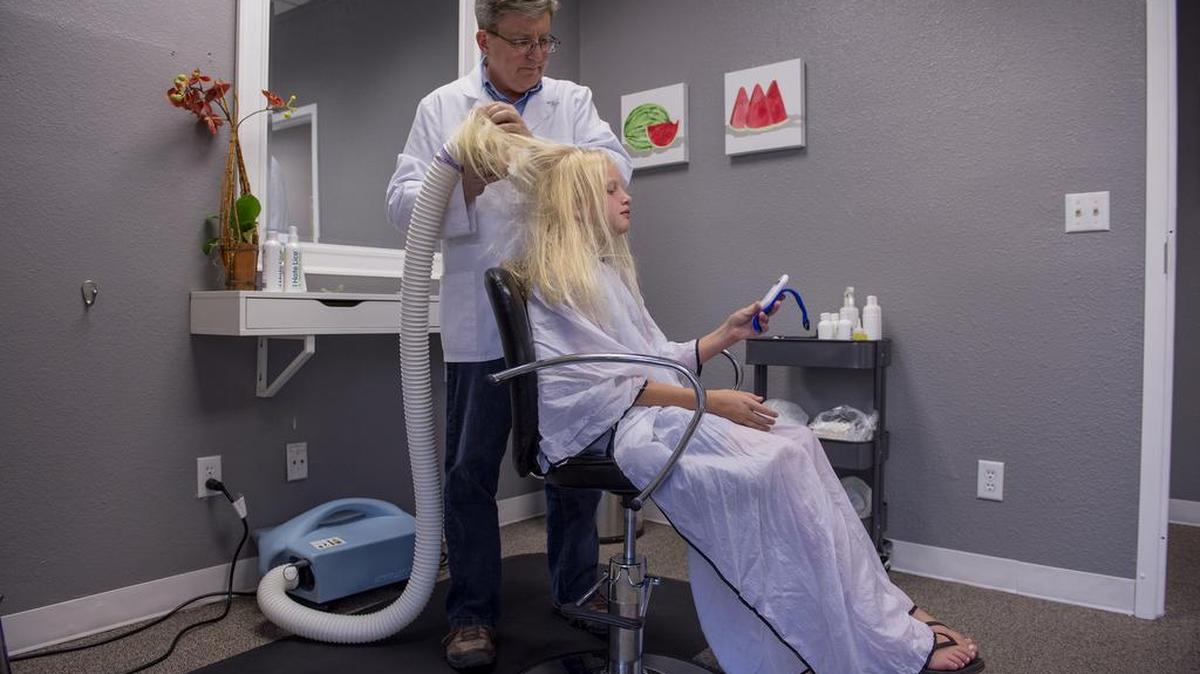 
Eric Heffel, a partner in the recently opened Lice Clinics of America Sacramento, uses a dehydration device to kill lice as he treats Marlie Wright of Lincoln earlier this month.
